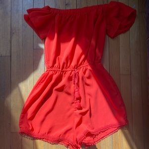 A red off the shoulders romper